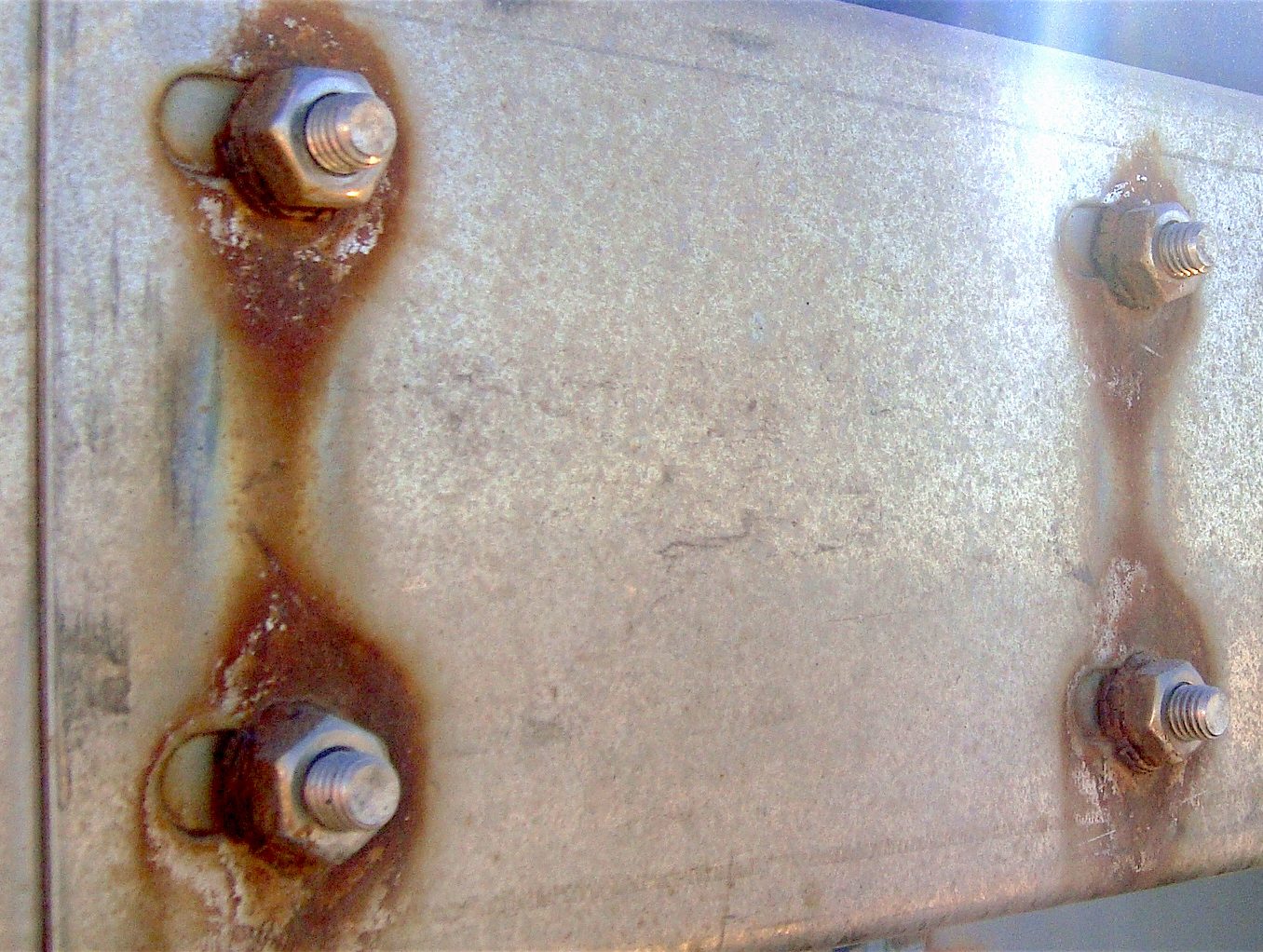 Galvanic corrosion due to differing anodic index between the bolts and the plate
